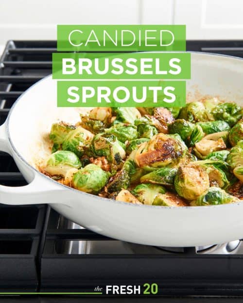 Golden brown candied brussels sprouts in a white skillet on a stovetop