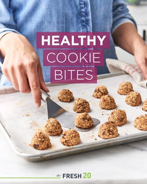 Woman with spatula takes a healthy cookie off of cookie sheet on a white marble surface