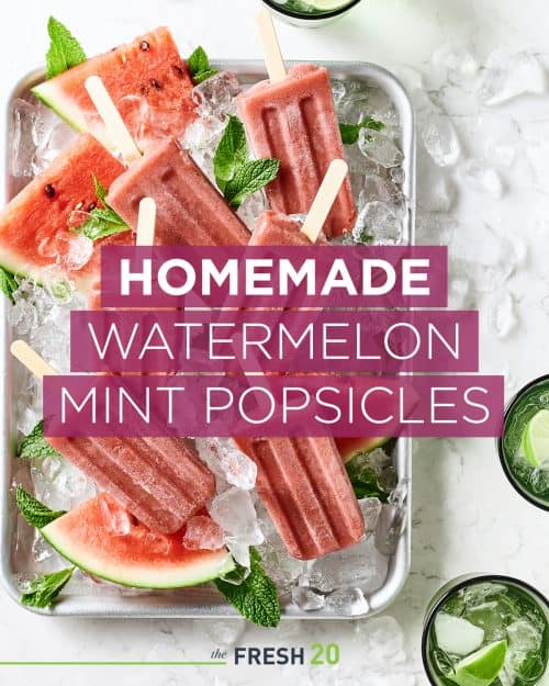 Sheetpan full of fresh watermelon and homemade watermelon mint popsicles with ice on a white marble surface