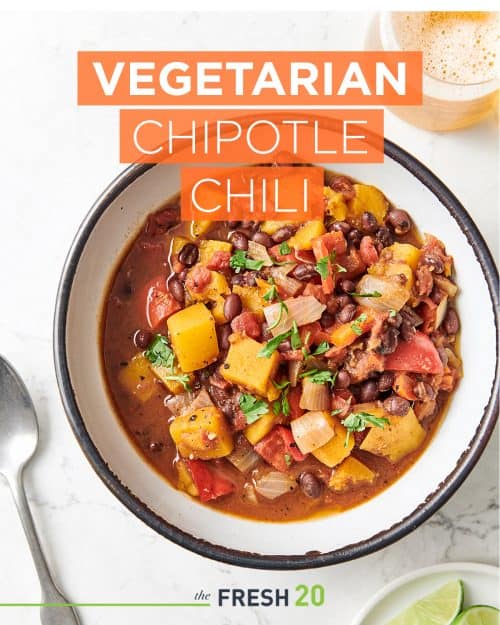 Hearty bowl of The Fresh 20 Instant Pot Crock-Pot vegetarian chipotle chili with lime wedges for entertaining from above