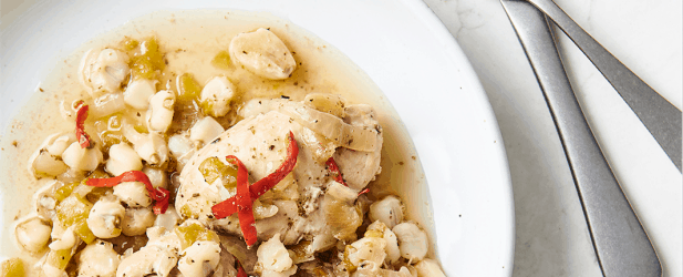 Plates of easy Instant Pot skinny chicken on a white marble surface with fork and knife