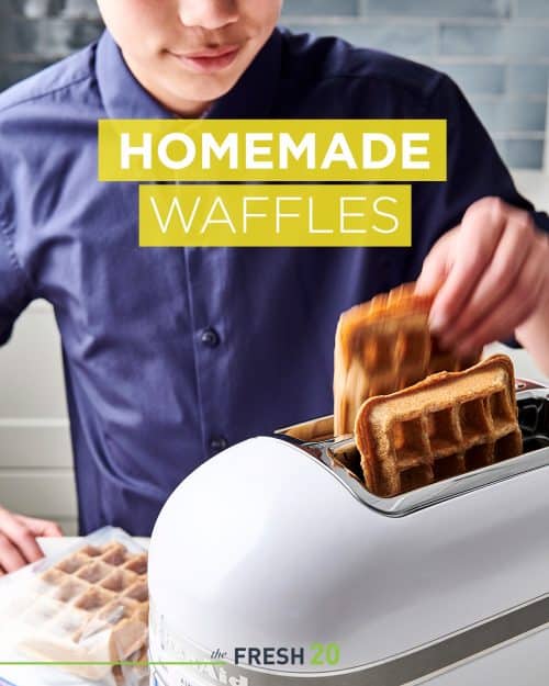 Young boy adding DIY homemade waffles into a white KitchenAid toaster in a beautiful kitchen