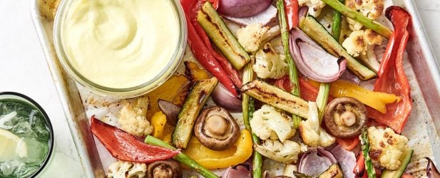 A perfect baking sheet pan filled with an assortment of roasted vegetables on a marble surface