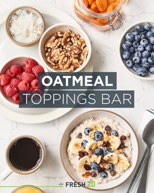 DIY bowl of oatmeal with a variety of blueberries, fruit & nut toppings with coffee on a white marble surface