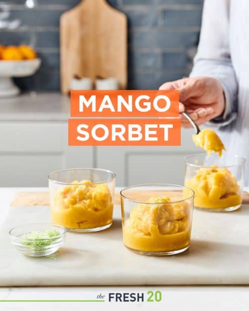 Three mini glass cups filled with quick & easy mango sorbet with lime zest in a white marble kitchen