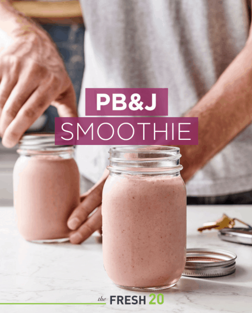 Man unscrewing lids on 2 mason jars filled with PB&J smoothie in a white marble kitchen
