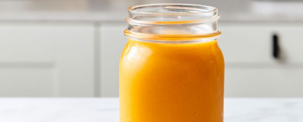 Mason jar of orange carrot ginger turmeric juice