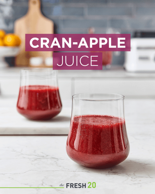 Two beautiful glasses filled with deep rich red cranberry apple juice in a white marble kitchen