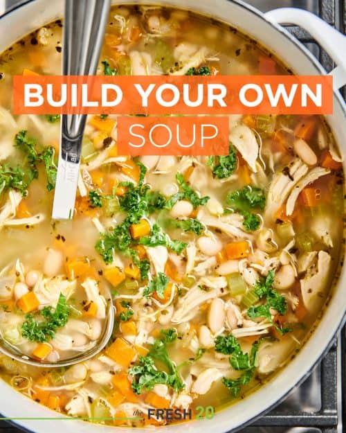 Pot of build your own soup with chicken, carrots and kale on the stove with a ladle from above