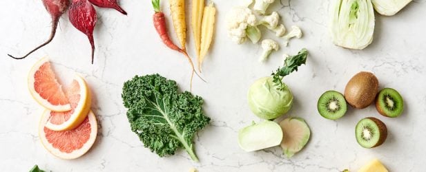 Assortment of spring vegetables and produce on a marble countertop