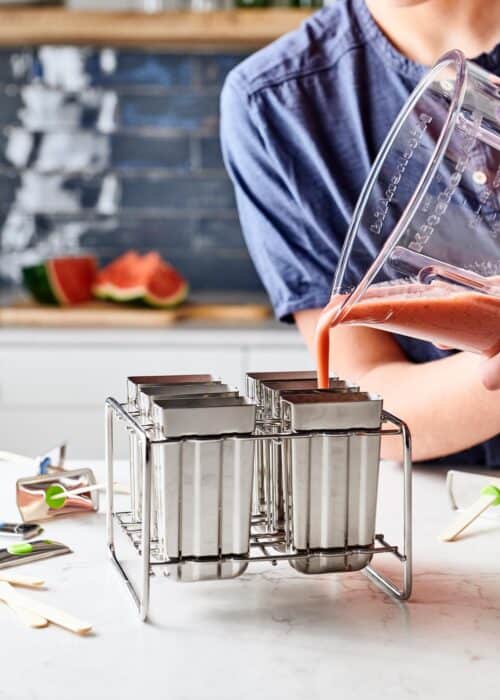 Pouring blended watermelon mint smoothie into metal popsicle forms