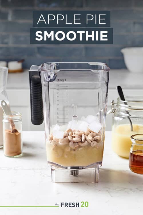 Blender full of easy healthy apple pie smoothie ingredients on a white marble surface in a beautiful kitchen
