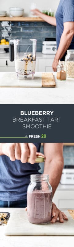 Man opening mason jar full of a vegan decadent blueberry breakfast tart smoothie in a white marble finished kitchen with a blender full of fruit