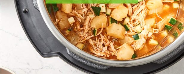 Hearty pineapple chicken Instant Pot Crock-Pot soup full of vegetables with a wooden spoon