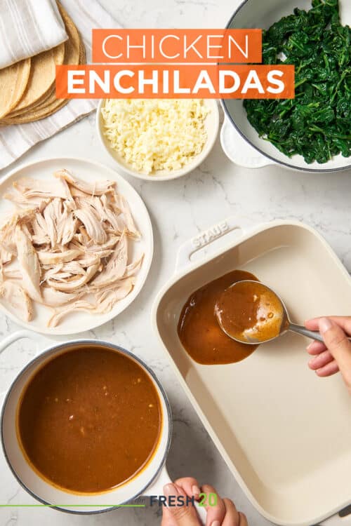 Preparing a Staub baking dish with mexican red sauce & ingredients for chicken & spinach enchiladas on white marble