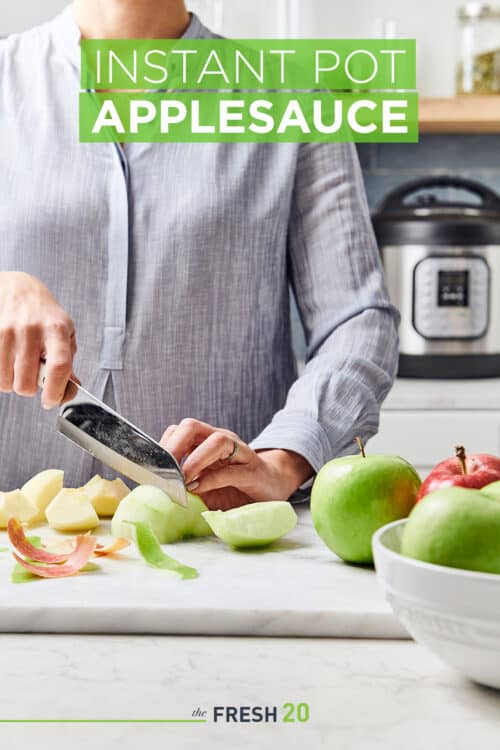 Woman slicing green apples on a white marble surface with an Instant Pot on the back counter in a beautiful modern kitchen
