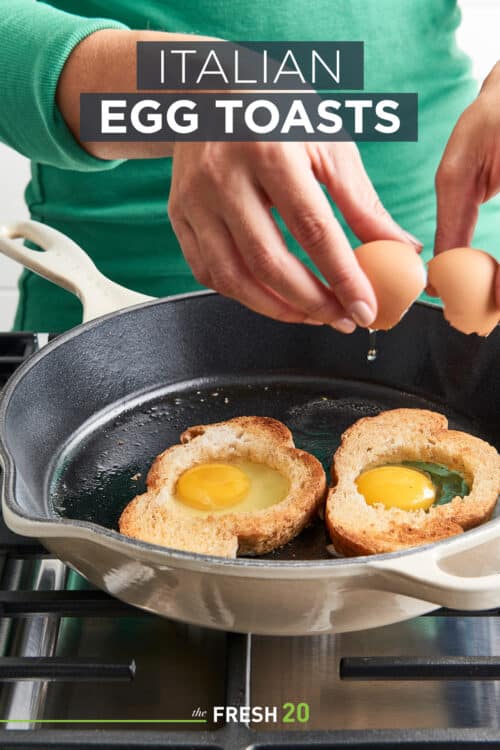 Woman cracking two eggs into two peices of hollowed out toast in a Le Creuset skillet on a metal cooktop