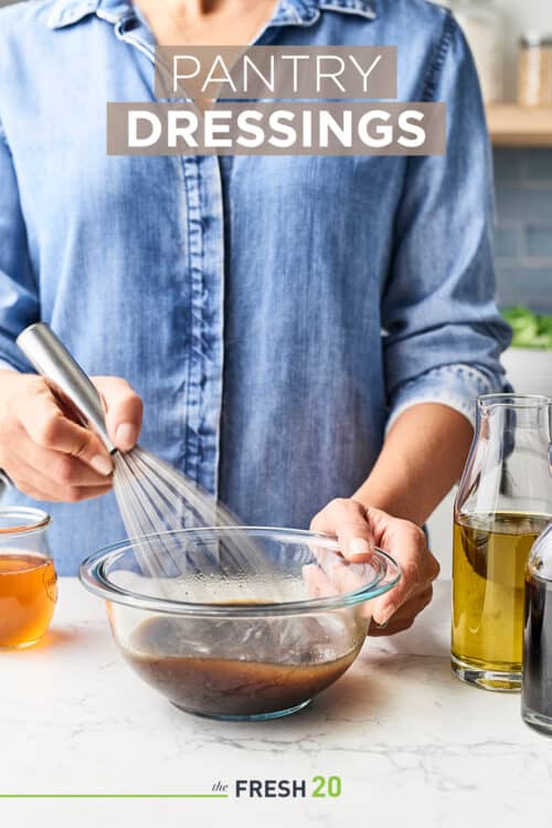 Woman whisking fresh homemade versatile pantry salad dressings on a white marble counter in a beautiful kitchen