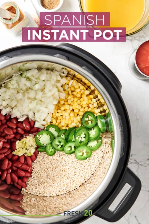Overhead view of The Fresh 20 Vegetarian Spanish Instant Pot Crock-Pot recipe organized with colorful vegetables and jalapeño
