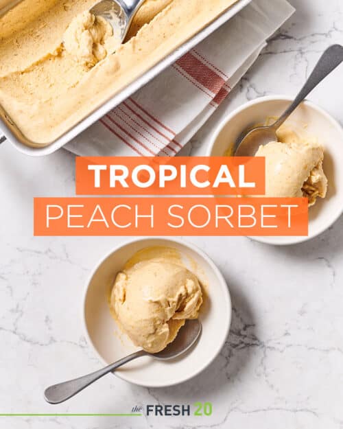 2 bowls and a tray with scoops of homemade peach sorbet on a white marble surface